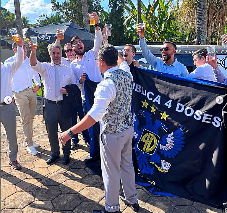 Ex-alunos brindando com a bandeira da república erguida