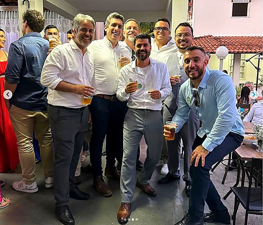 Ex-alunos reunidos de camisa social num evento