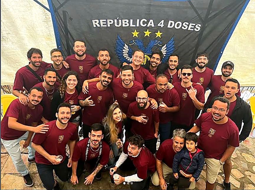 Turma reunida de camisa vinho sob a bandeira da 4 Doses