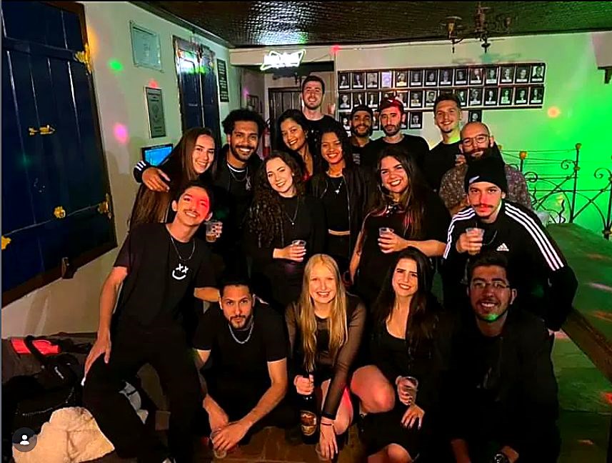 Turma reunida numa festa à noite na república