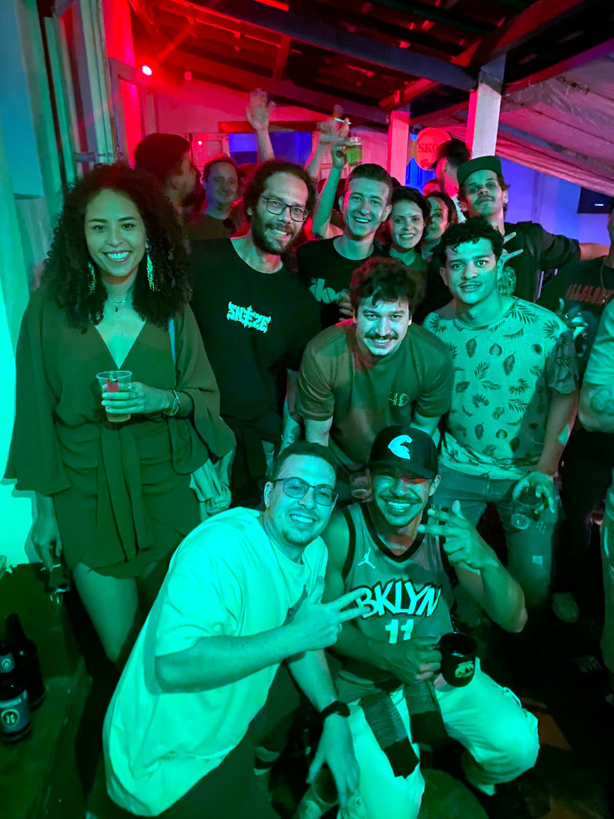 Turma reunida na pista de dança com iluminação verde